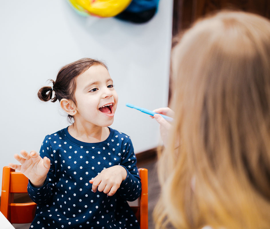 Myofunctional therapy helping child with oral motor exercises
