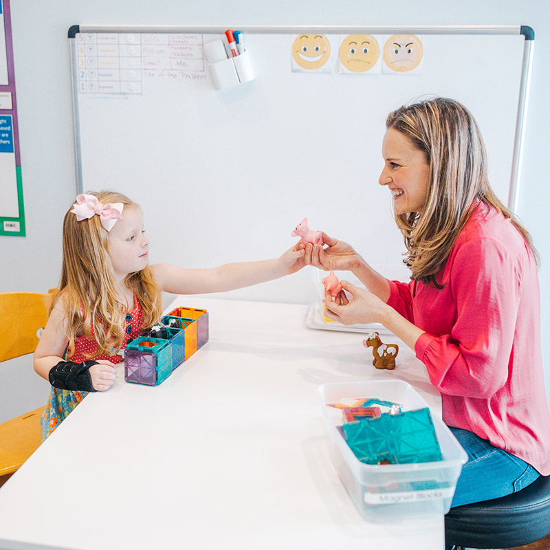 Speech therapist working with child during therapy session